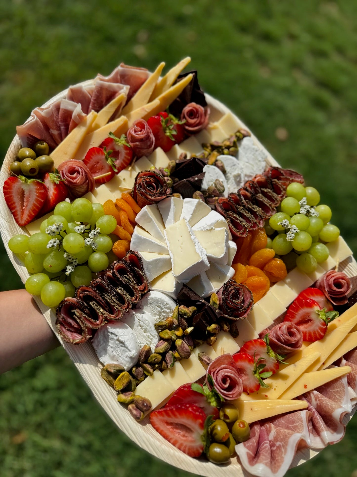 Assorted charcuterie board with cheese, fruits, and meats on a wooden board.